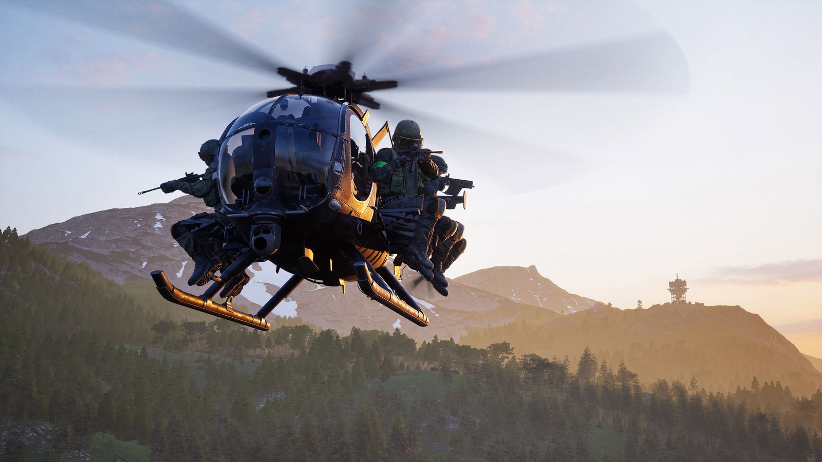 A Little Bird helicopter in WARDOGS flying toward the camera with soldiers seated on its external benches, over pine-covered hills