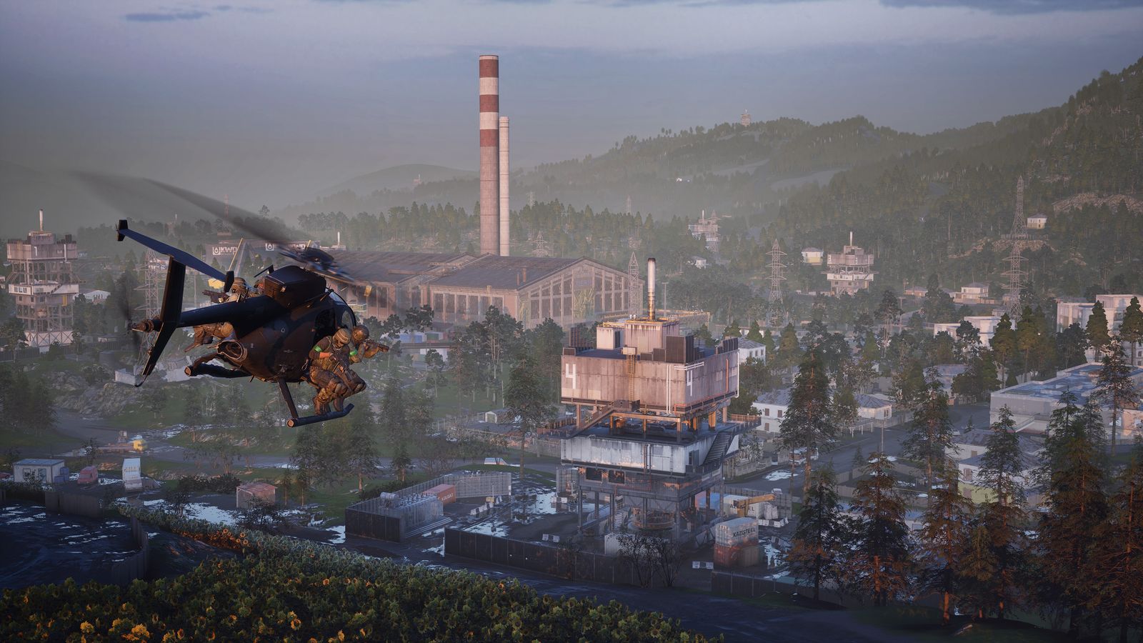 A Little Bird helicopter with soldiers on its side benches flying low over an industrial town with a tall chimney in WARDOGS