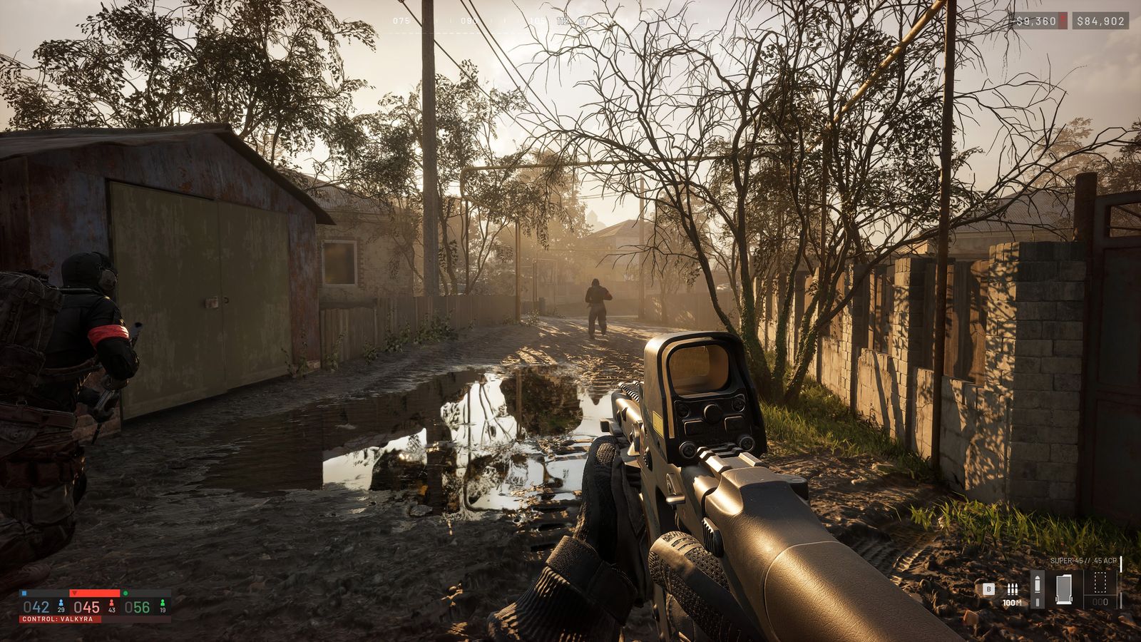 First-person view down a muddy WARDOGS street with wooden fences, bare trees and a distant soldier, HUD visible
